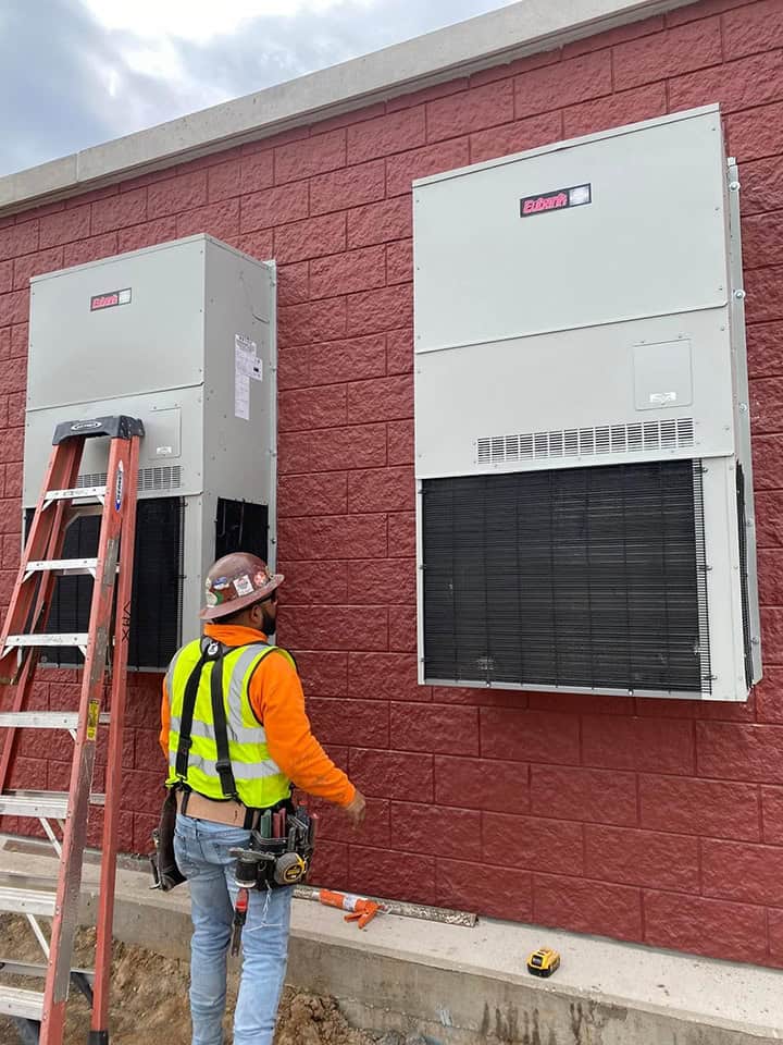 A technician from Bolton Heating & Air performing diagnostics on a malfunctioning HVAC unit in Forney