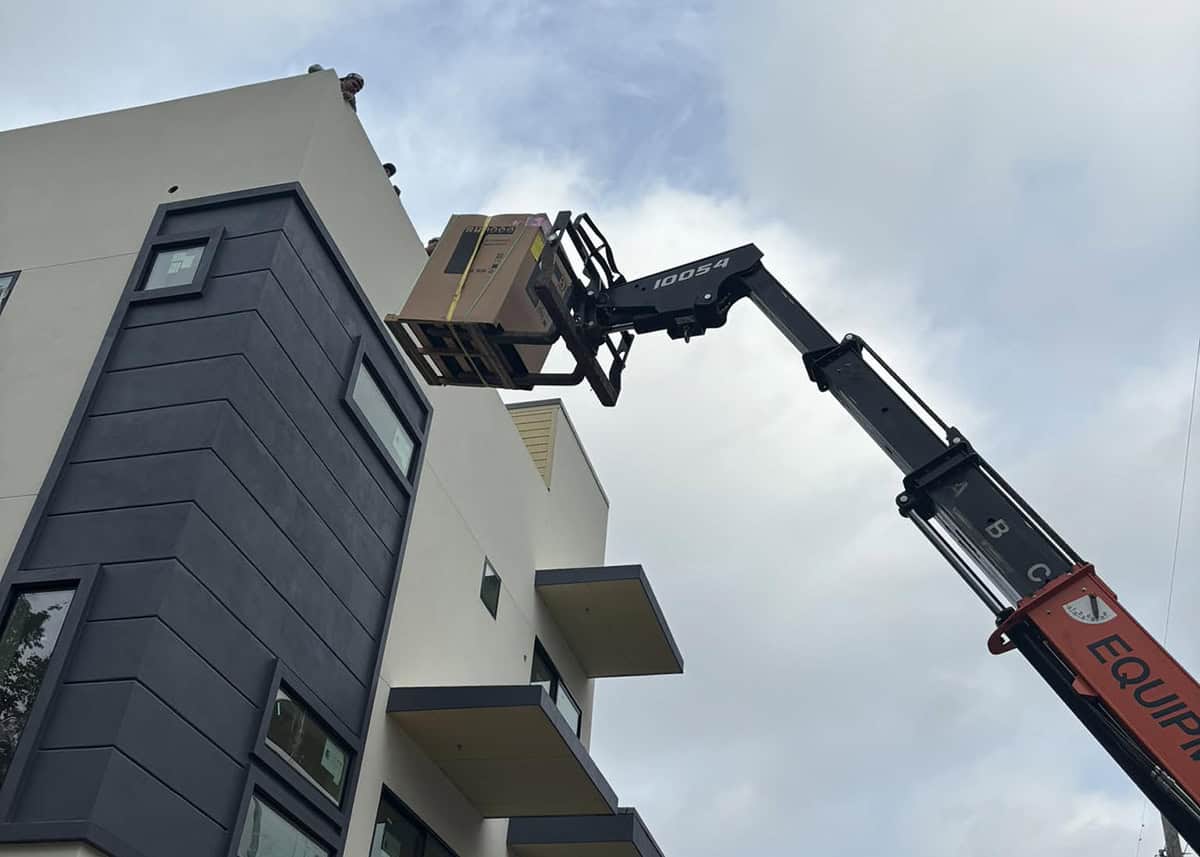 HVAC installation with crane lifting new air conditioning unit onto building roof in Forney, TX – Bolton Heating & Air