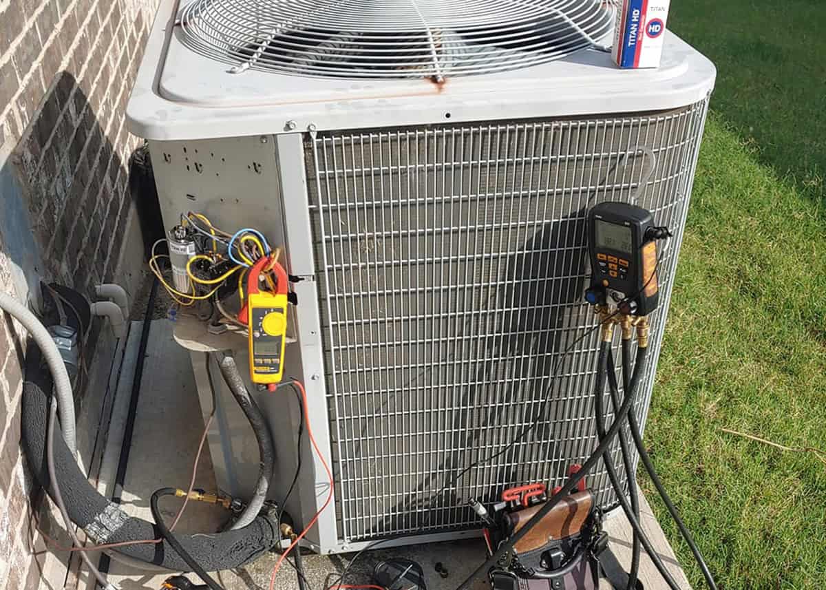 Licensed HVAC technician performing AC repair service on residential air conditioning unit in Dallas Fort Worth area