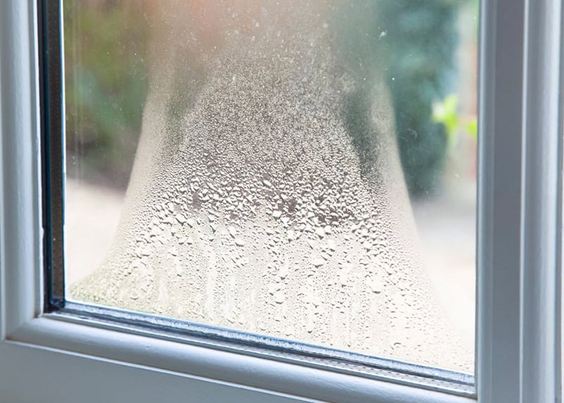Condensation forming on a home window pane, a common sign of excessive indoor humidity that Dallas-Fort Worth homeowners should monitor to prevent moisture damage and mold growth.