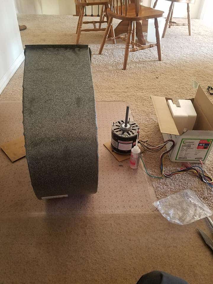 Furnace blower fan and motor removed from a heating system during furnace fan repair service.