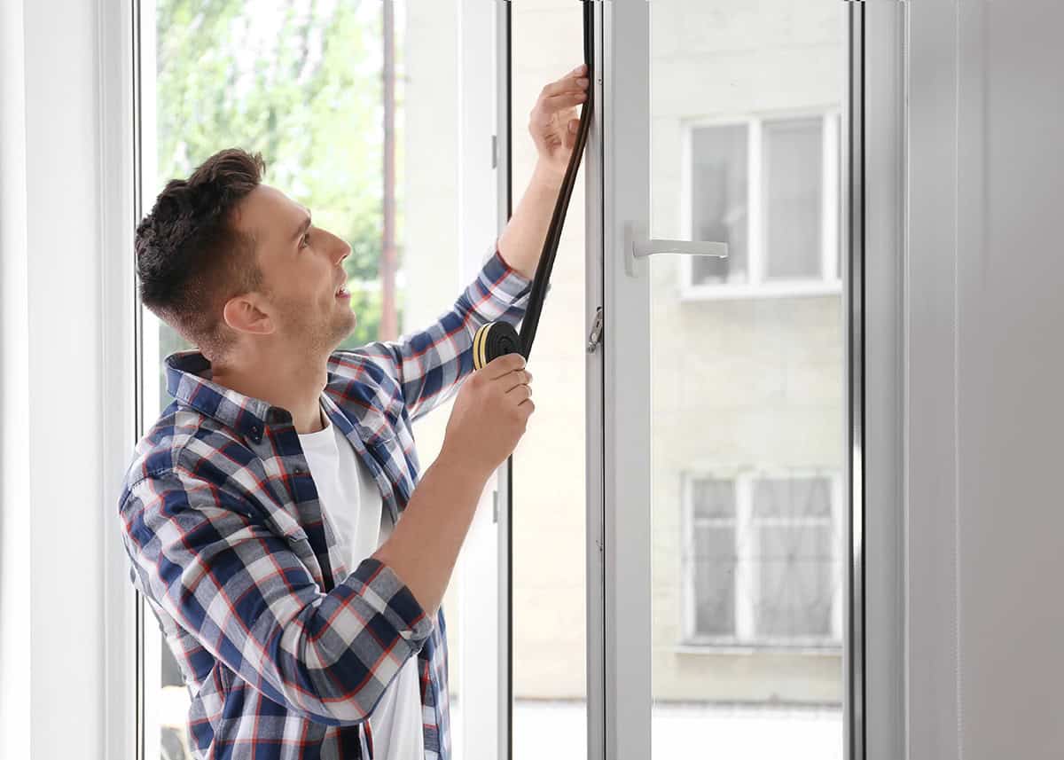 Homeowner Applying Foam Insulation On Windows