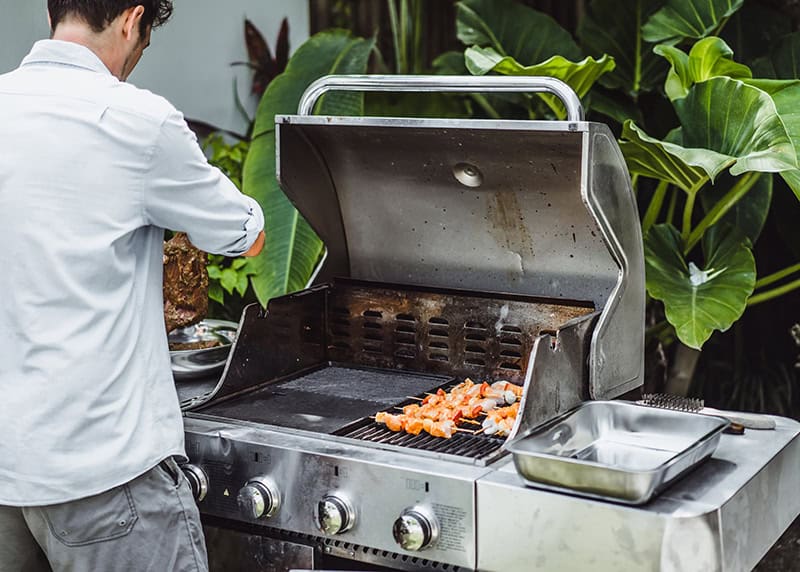 Man relaxing in front of a barbeque grill in the summer time