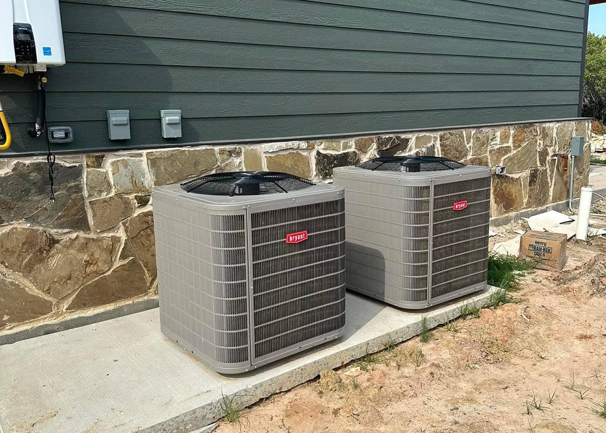 Two new Bryant AC units installed outside a 2000 square foot house in Dallas-Fort Worth, showing professional central air conditioning system replacement